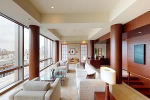 a living room with white furniture and large windows at Grand Hyatt Tokyo in Tokyo