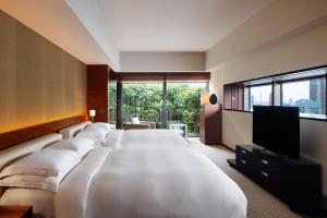 a hotel room with a large bed and a flat screen tv at Grand Hyatt Tokyo in Tokyo