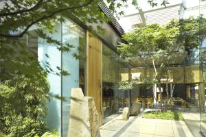 a glass facade of a building with trees at Grand Hyatt Tokyo in Tokyo +170 photos