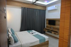 a hotel room with a bed and a television at Hotel Heritage Prime Junagadh in Junagadh
