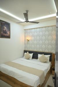 a bedroom with a bed with a ceiling fan at Hotel Heritage Prime Junagadh in Junagadh