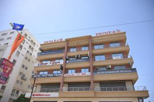 a tall building with a flag in front of it at Hotel Heritage Prime Junagadh in Junagadh