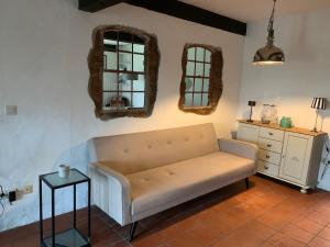 a living room with a couch and two mirrors at Haus Siebenstein Living for a good cause in Drochtersen +53 photos