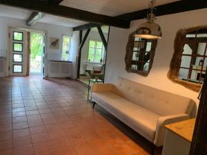 a living room with a couch and a tile floor at Haus Siebenstein Living for a good cause in Drochtersen