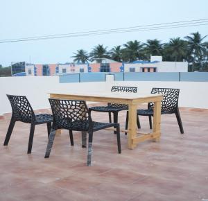 a wooden table and chairs on a roof at La Coral Residency in Pondicherry