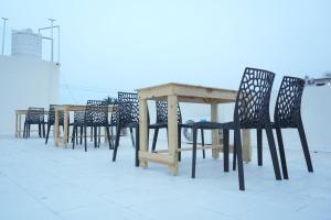 a group of chairs and a wooden table on a roof at La Coral Residency in Pondicherry