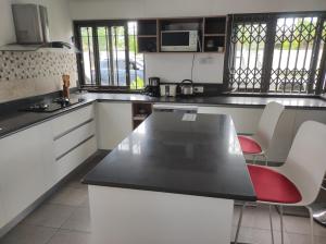 a kitchen with white cabinets and a black counter top at mahogany villa in Grand-Baie +5 photos