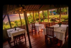 a restaurant with tables and chairs and a view of the ocean at Lambawany in Sainte Marie