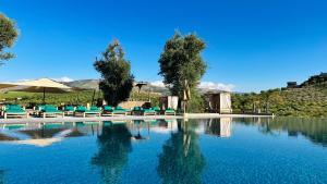 a pool of water with chairs and trees at Kaha Lak in Douar Aguergour