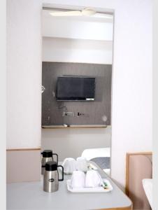 ein Badezimmer mit Waschbecken mit Spiegel und Kaffeemaschine in der Unterkunft Hotel Excellency in Dīsa