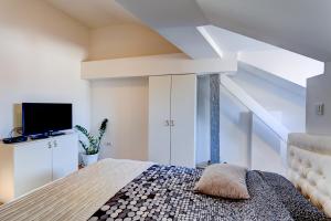 Habitación blanca con cama y TV en Apartments Selfie Belgrade Central, en Belgrado