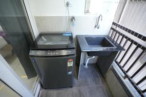 a small kitchen with a sink and a trash can at Hotel Flamount Arka Studios in Hyderabad +34 photos