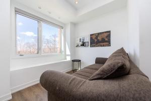 a living room with a couch and a window at Downsview Park Luxury Townhome near Yorkdale Transit in Toronto