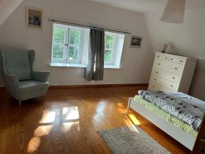 a bedroom with a bed and a dresser and a chair at Haus Adele in Drochtersen
