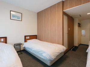 a bedroom with a bed and a door to a room at Hotel Union in Kagoshima