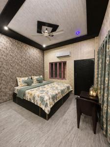 a bedroom with a large bed and a table at HOTEL SHIVAYY MAJESTIC - BHU Sundarpur Road 3km from KASHI VISHWANATH TEMPLE in Varanasi +21 photos