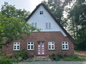 a red brick house with a white roof at Haus Adele in Drochtersen +22 photos