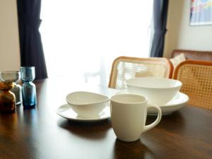 a wooden table with two cups and plates on it at MSTAY池袋one in Tokyo