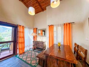 a living room with a wooden table and a large window at Pillow on the Cloud in Rāmgarh +17 photos