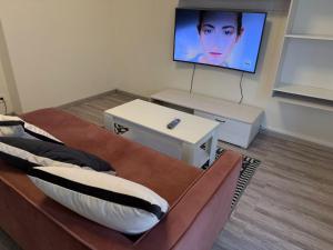 a living room with two beds and a flat screen tv at Colombo 49 Guest House in Gallarate