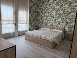 a bedroom with a bed and a floral wall at Colombo 49 Guest House in Gallarate