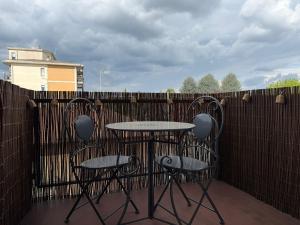 a table and two chairs on a patio with a fence at Colombo 49 Guest House in Gallarate
