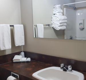 a bathroom with a sink and a mirror and towels at Retasket Lodge & RV Park in Lillooet