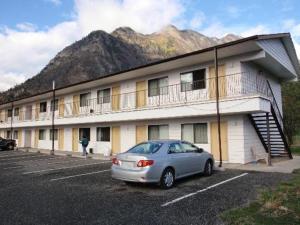 a car parked in a parking lot in front of a building at Retasket Lodge & RV Park in Lillooet
