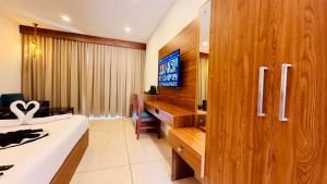 a bedroom with a bed and a desk and a television at Skylark Holidays Chinnakanal in Chinnakanal