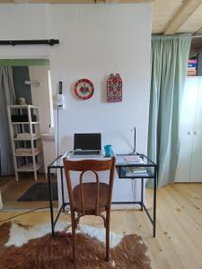 a desk with a laptop and a chair in a room at Mera Small House in Mera