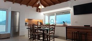a kitchen with a table and chairs and a refrigerator at Hercules casa in Kymi