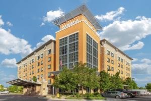 a hotel building with cars parked in a parking lot at Cambria Hotel Denver International Airport in Aurora