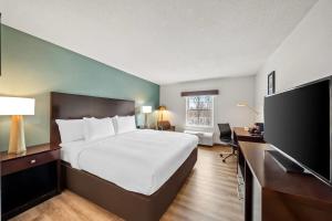 a hotel room with a bed and a flat screen tv at Comfort Inn Foxboro - Mansfield in Foxborough