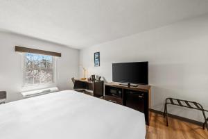 a bedroom with a bed and a flat screen tv at Comfort Inn Foxboro - Mansfield in Foxborough