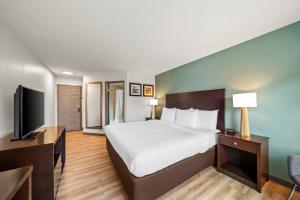 a hotel room with a bed and a flat screen tv at Comfort Inn Foxboro - Mansfield in Foxborough
