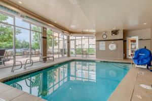 a swimming pool in a building with a large window at Cambria Hotel Denver International Airport in Aurora