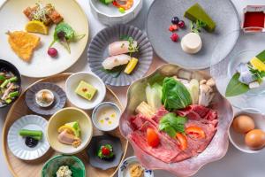 a table topped with plates of food and bowls of food at Hotel MODA in Yufu +86 photos