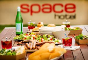a table with plates of food and a bottle of beer at Space Hotel in Melbourne