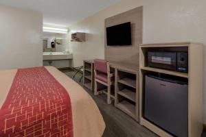 a small hotel room with a bed and a kitchen at Rodeway Inn Ardmore I-65 in Elkton
