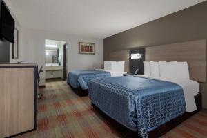 a hotel room with two beds and a flat screen tv at Rodeway Inn Ardmore I-65 in Elkton +21 photos