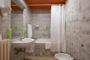 a bathroom with a sink and a bath tub at Brijuni Hotel Neptun in Fažana +35 photos