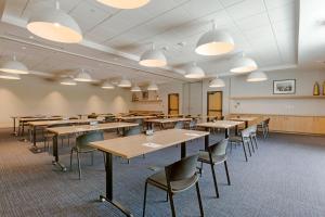 an empty classroom with tables and chairs and lights at Cambria Hotel Austin Airport in Austin +82 photos
