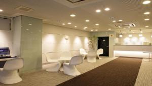 a waiting room with white chairs and a table at Hotel Green Palace in Sendai