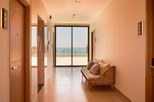 a living room with a couch and a view of the ocean at Sala Hotel Phan Thiet in Phan Thiet +23 photos