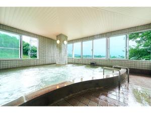 a pool of water in a room with windows at Tabist Yuasa Castle Onsen Hotel in Yuasa +87 photos
