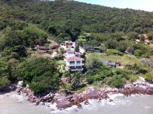 una vista aérea de una casa en una isla rocosa en el agua en Praia Recanto das Pedras, en Governador Celso Ramos
