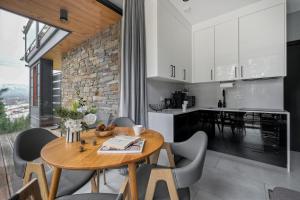 a kitchen and dining room with a wooden table and chairs at Apartament Białka SKI - 200m do Term Bania, blisko natury in Białka Tatrzańska
