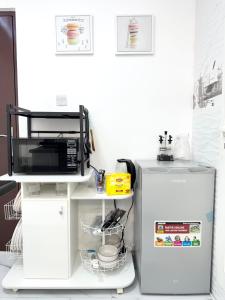 a kitchen with a microwave and a refrigerator at Velmora 1BR Apartment 13 in Abu Dhabi +7 photos