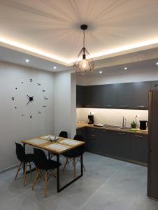 a kitchen with a table and a clock on the wall at Luxury Rofos Residence in Elounda