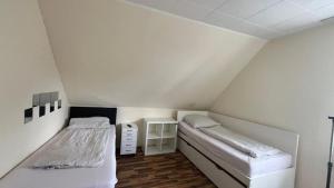 a room with two beds in a small room at Pension Highway - Bünde Vincke Straße 11 in Bünde
